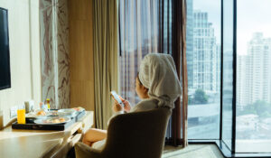 Female hotel guest relaxing in her room.