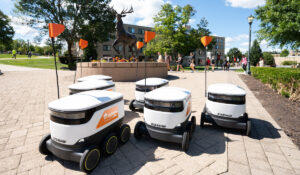 A group of self driving robots traveling across a college campus.